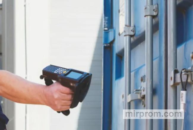 Инженер сканирует QR-код на индивидуальном полимерном маркере безопасности с помощью мобильного терминала сбора данных