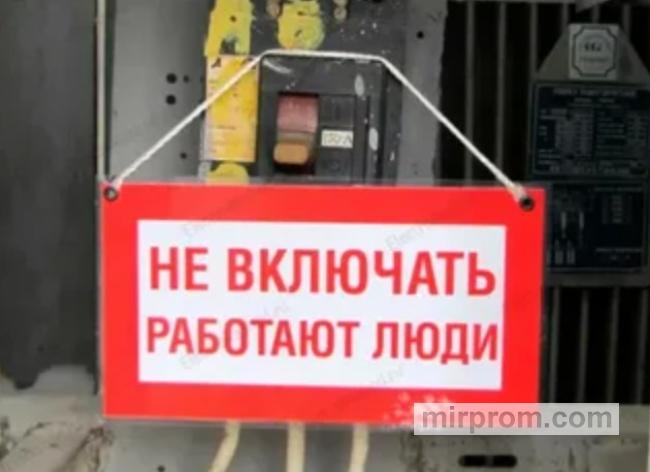 Красная пластиковая табличка с надписью «Не включать, работают люди», закрепленная стяжкой на рычаге силового автомата в распределительном щите